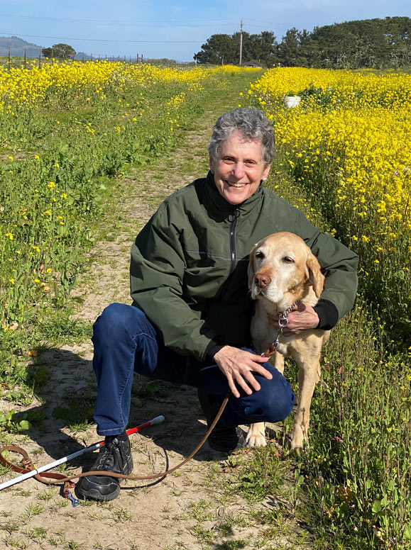 Author with guide dog Fresco in field of yellow flowers