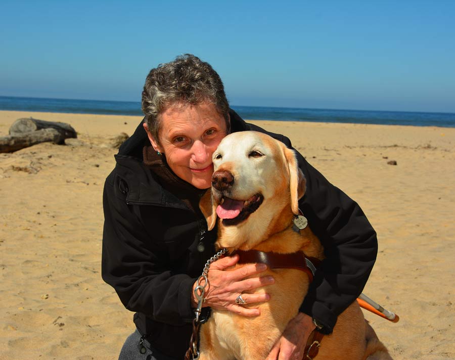 Photo of Susan hugging Teela, ocean in background