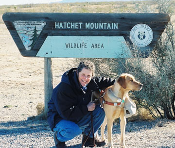 Photo of author with Teela beneath a sign for Hatchet Mountain Wildlife Area